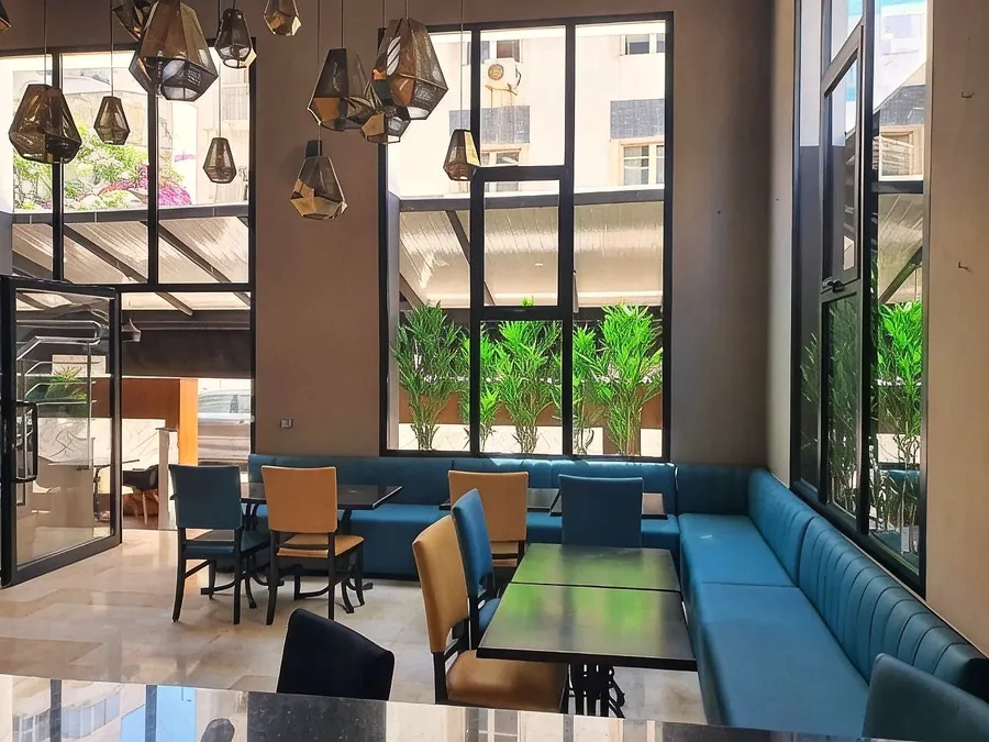 Banquette bleu canard le long des baies vitrées
