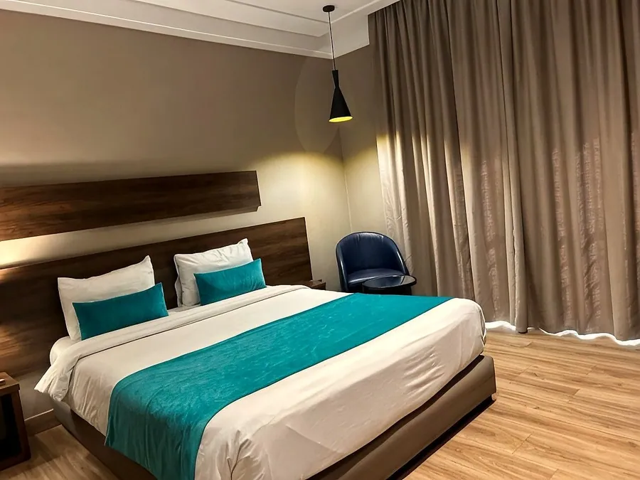 Chambre Confort, jeté de lit bleu canard et fauteuil