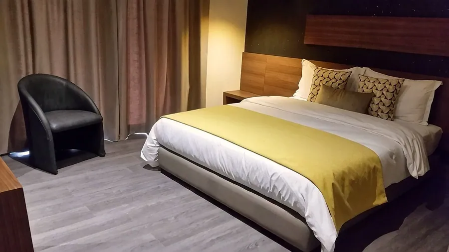 Chambre Premium, jeté moutarde et fauteuil noir